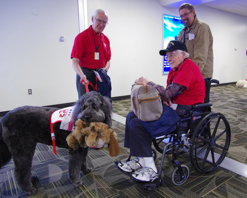 Nellie Belle shows her new friends her favorite stuffed toy at the airport.